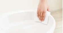 手前のフチを布でつまんで拭く様子